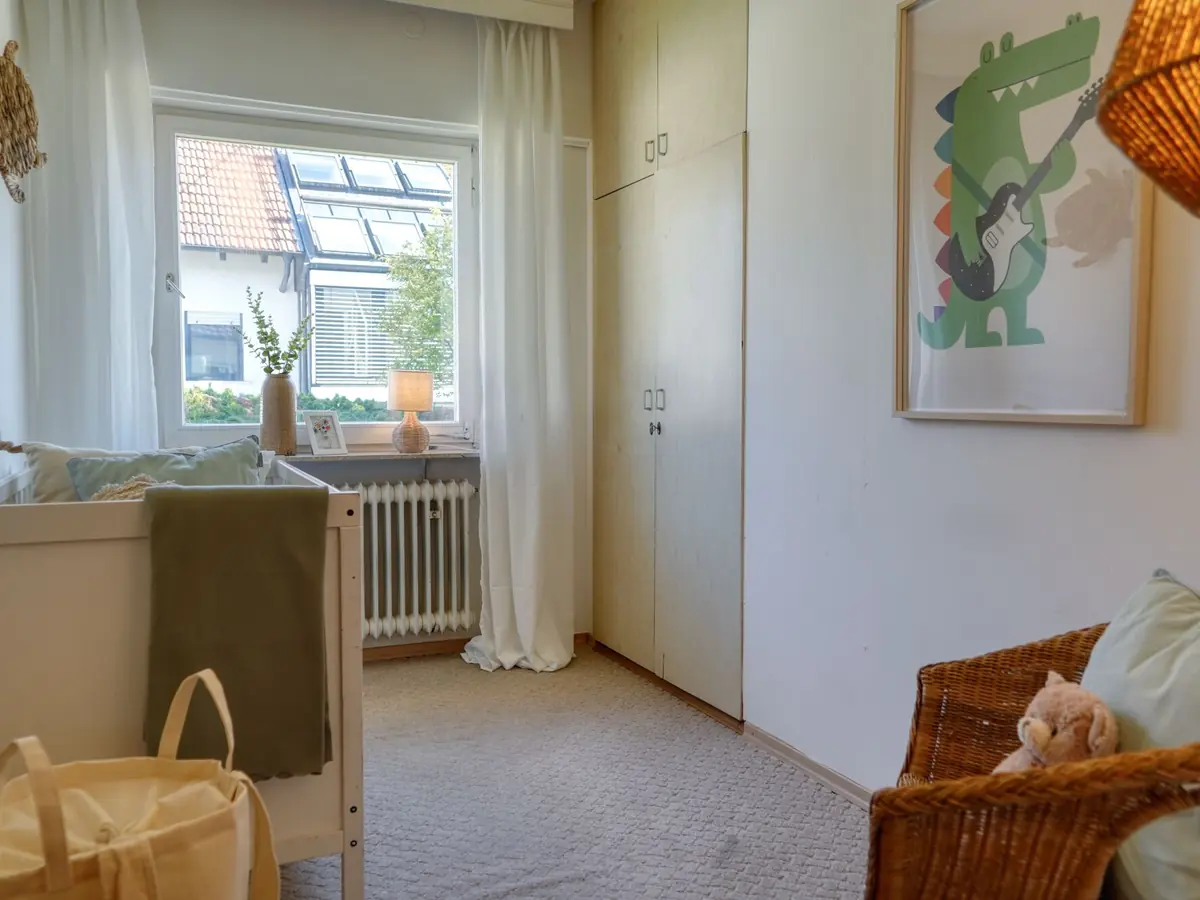 Nachher: helles Babyzimmer mit Korbwiege und Wandbild
