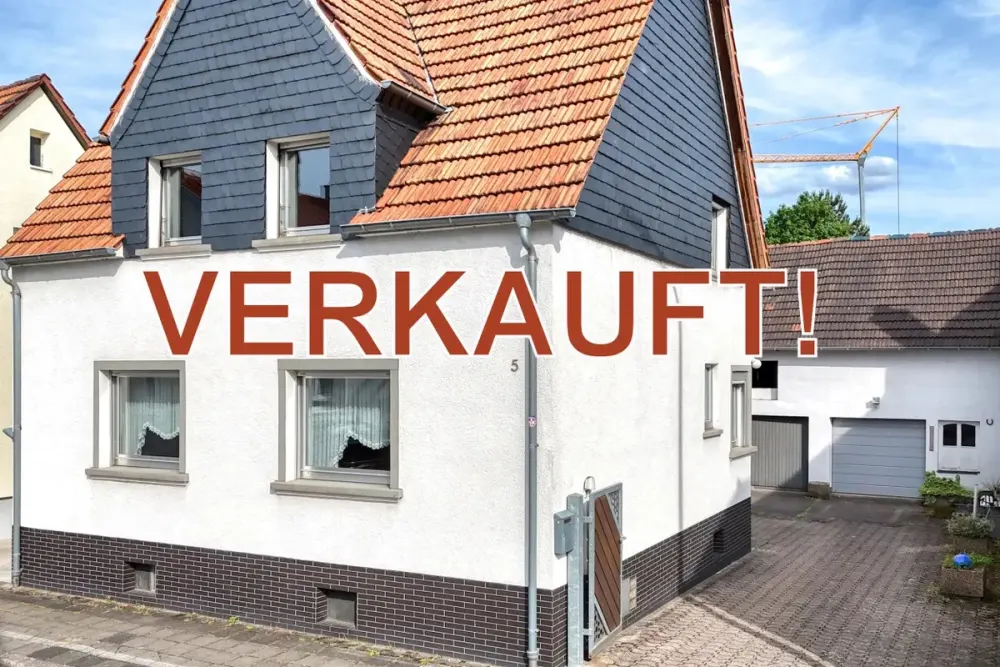 Verkauftes Einfamilienhaus in Jockgrim mit Schieferverkleidung am Giebel, daneben Hof und Scheune